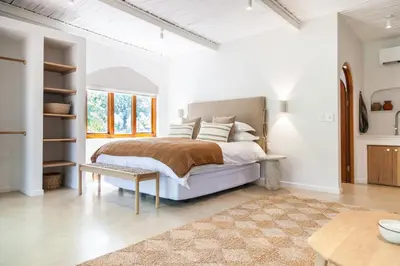 a white bedroom with a bed and a table at The Oak Cottage in Wellington