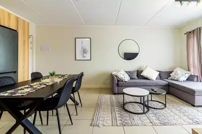 a living room with a couch and a table at #AlimamaSpaces Thando's Fynbos in Cape Town