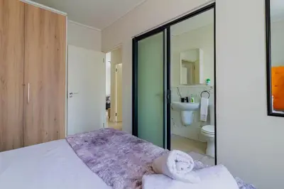 a bedroom with a bed and a bathroom with a toilet at #AlimamaSpaces Thando's Fynbos in Cape Town