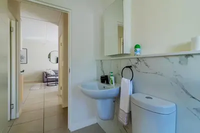a white bathroom with a sink and a toilet at #AlimamaSpaces Thando's Fynbos in Cape Town