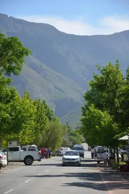 a street with cars parked on the side of a mountain at TheBlueDoor in Greyton