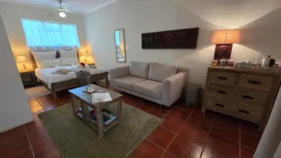 a living room with a couch and a bed at TheBlueDoor in Greyton