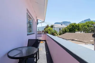 a table and chairs on the balcony of a house at First floor Claremont Studio apartment in Cape Town