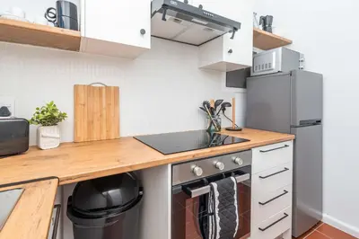 a kitchen with a sink and a refrigerator at First floor Claremont Studio apartment in Cape Town