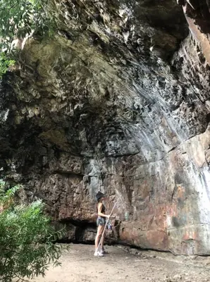 a woman standing in front of a rock wall at Kerala Cottage - farm charm inspired self-catering