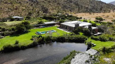 an aerial view of a house with a lake at Drakenskloof - Exclusive-Use Mountain Homestead