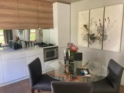 a kitchen with a glass table and some chairs at Swan Cottage in Kylemore