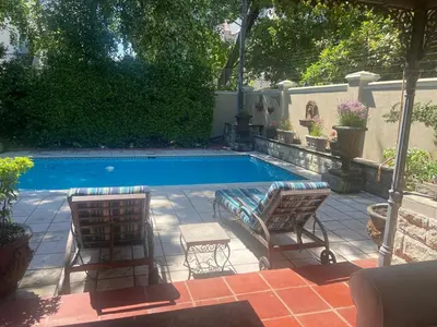 two chairs and a swimming pool in a yard at Heldeberg 6 in Stellenbosch