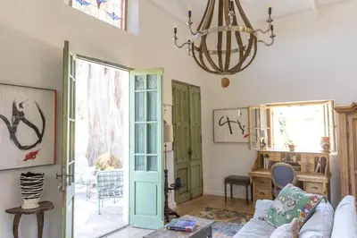 a living room with a couch and a chandelier at Authentic and Charming French-inspired Cottage in Franschhoek
