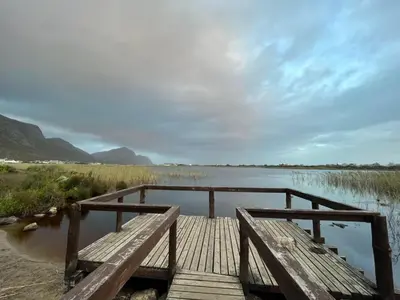a wooden bridge over a body of water at Silversands Serenity in Bettyʼs Bay