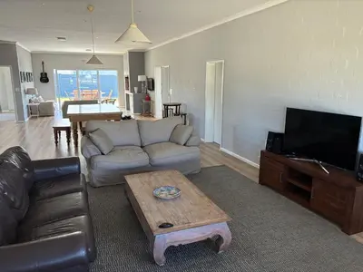 a living room with a couch and a coffee table at Silversands Serenity in Bettyʼs Bay