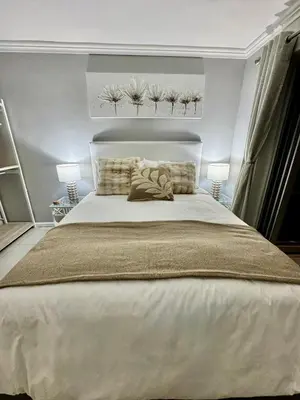 a bedroom with a large white bed with two lamps at 3at33 CT in Cape Town