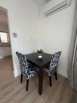 a black table with two chairs and a plant on it at Plattekloof Mountain view in Plattekloof
