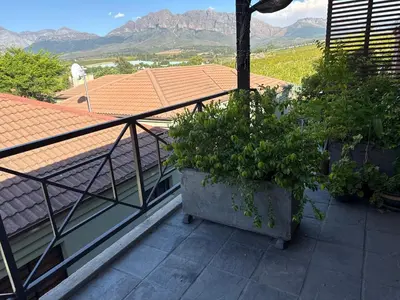a balcony with two potted plants on a roof at Balcony mountain views free fibre-wifi aircon and parking in Wellington