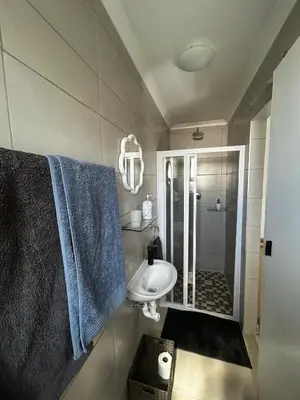 a bathroom with a sink and a shower with blue towels at Dove Cottage in Oakdale