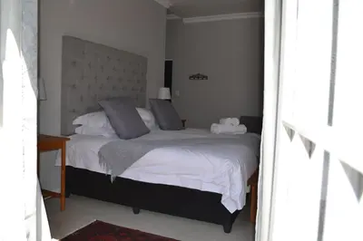 a bedroom with a large bed with two pillows at The Garden Shed Guest House in Wellington