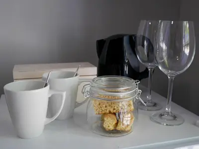 a table with a jar of food and two wine glasses at The Garden Shed Guest House in Wellington