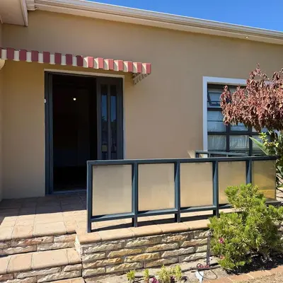 a house with a fence in front of a door at Home of peace self catering accommodations