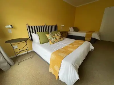 a hotel room with two beds and a table at Salty Leaves in Hermanus