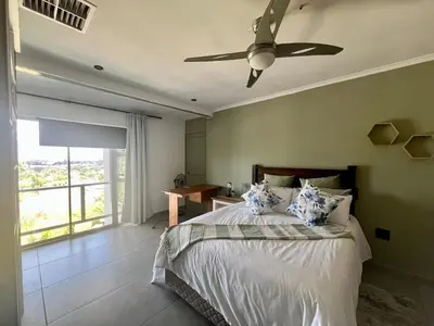 a bedroom with a bed with a ceiling fan at Paarl View House in Paarl