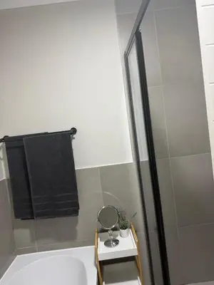 a bathroom with a bath tub and a mirror at Modern stay overlooking Durbanville wine country in Durbanville