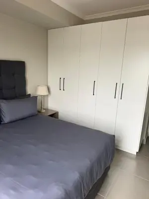 a bedroom with white cabinets and a blue bed at Modern stay overlooking Durbanville wine country in Durbanville