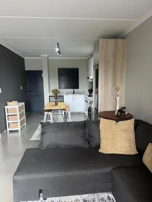 a living room with a couch and a table at Modern stay overlooking Durbanville wine country in Durbanville