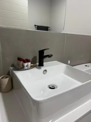 a white sink in a bathroom with a mirror at Modern stay overlooking Durbanville wine country in Durbanville