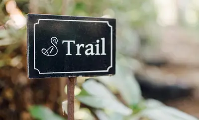 a black sign that says trail at Amour in Pniel