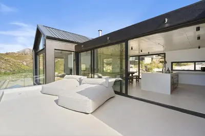 a living room with white furniture and large windows at Nowhere Els in Rooiels