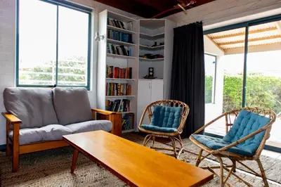 a living room with a couch and two chairs at Bagatelle in Pringle Bay