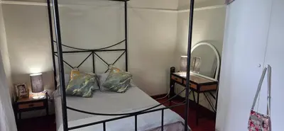 a bedroom with a four poster bed and a mirror at Bot River Farm Cottage in Botrivier