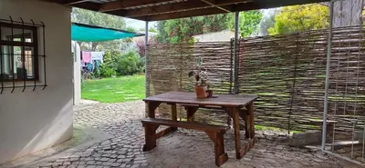 a wooden table with a lamp on a patio at Bot River Farm Cottage in Botrivier