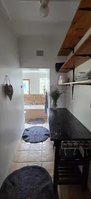 a kitchen with a table in a room with a window at Bot River Farm Cottage in Botrivier