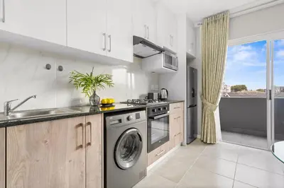 a kitchen with a washer and a dishwasher at The Orion 16 in Table View