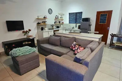 a living room with a couch and a kitchen at Bed and Biscuits in Windmeul