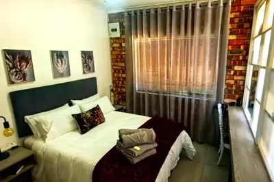 a bedroom with a bed and a window at Bed and Biscuits in Windmeul
