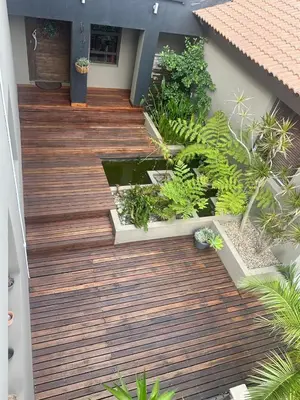 a wooden deck with plants on a house at Chasing Sunsets sea and mountain views in Hermanus