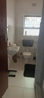 a bathroom with a sink and a toilet and a window at Accomodation in Cape Town in Goodwood