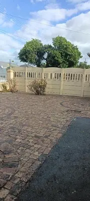 a fence in front of a building with trees in the background at Accomodation in Cape Town in Goodwood