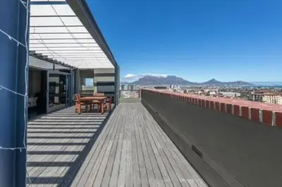 a balcony of a building with a table and chairs at Ezey Tours-Manhattan Suites in Cape Town