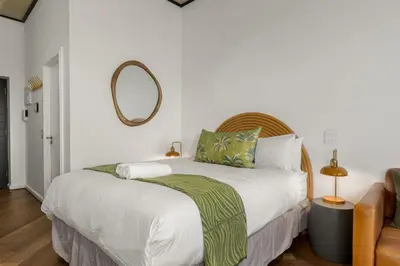 a bedroom with a bed with a mirror on the wall at Bridgewater One 206 in Cape Town