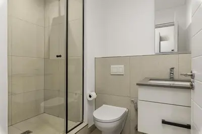 a bathroom with a toilet and a glass shower at Bridgewater One 206 in Cape Town