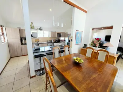 a kitchen and dining room with a wooden table and chairs at 22 on Breezand in Cape Town