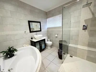 a bathroom with a tub and a sink and a toilet at 22 on Breezand in Cape Town