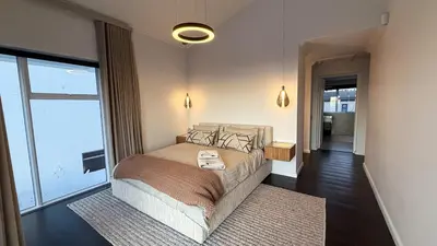 a bedroom with a bed and a large window at The Sunset Edition in Cape Town