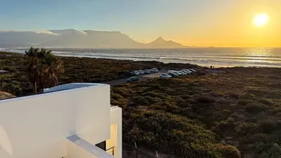 a group of cars parked on the beach at sunset at The Sunset Edition in Cape Town