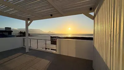 a view of the sunset from a balcony of a house at The Sunset Edition in Cape Town