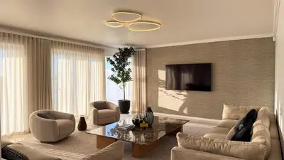 a living room with a couch and a tv at The Sunset Edition in Cape Town