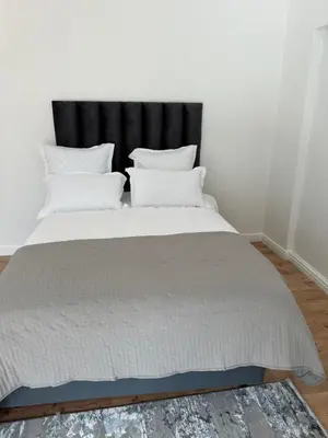 a bed with white pillows and a black headboard at Plattekloof guest house in Tygerberg Hills